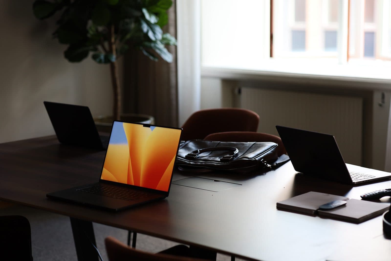 Laptops uppfällda på ett mötesbord
